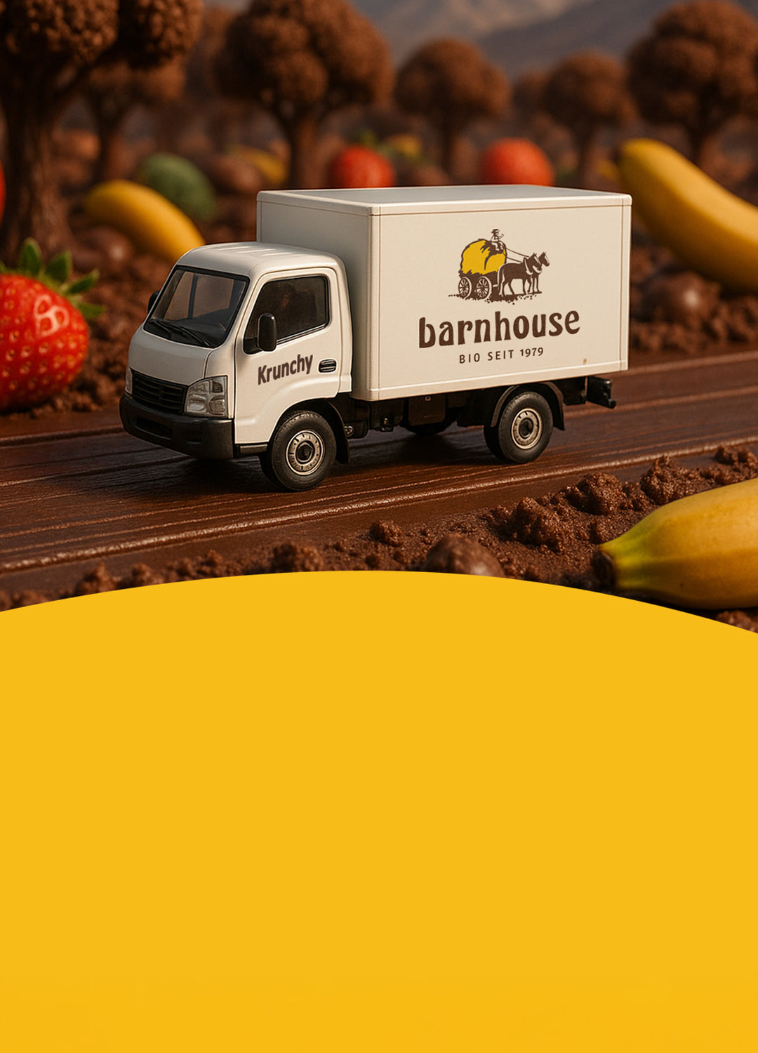 Weißer Lieferwagen mit Barnhouse-Logo und Krunchy-Aufschrift, der auf einer braunen Schoko-Straße durch eine schokoladige Landschaft mit braunen Bäumen, Äpfeln, Bananen und Erdbeeren fährt.