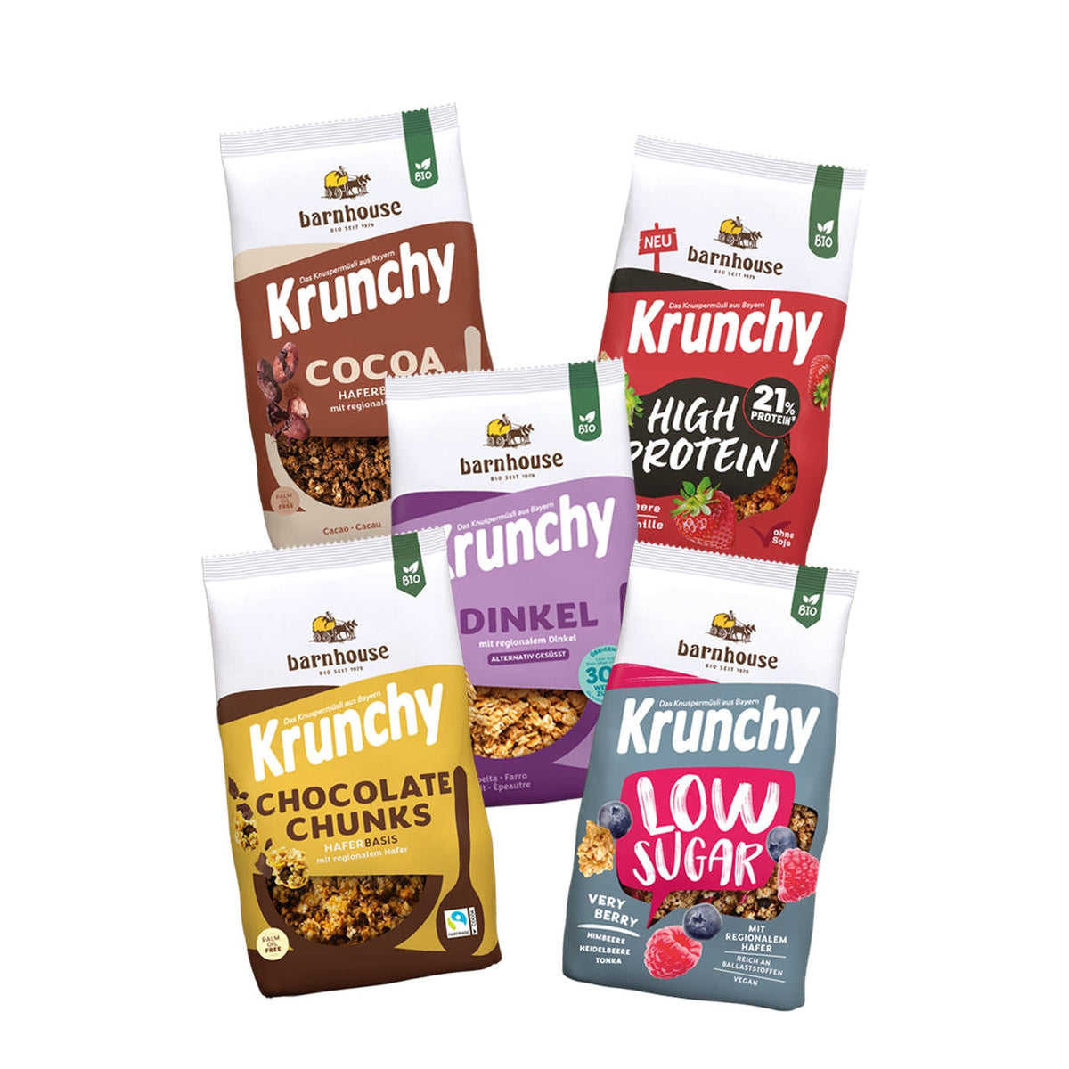 Blick von vorne auf die fünf Packungen Krunchy Cocoa weniger Zucker (braun-beige) High Protein (rot-schwarz), Dinkel weniger Zucker (violett), Chocolate Chunks (gelb-braun) und Low Sugar Very Berry (rot-blau)