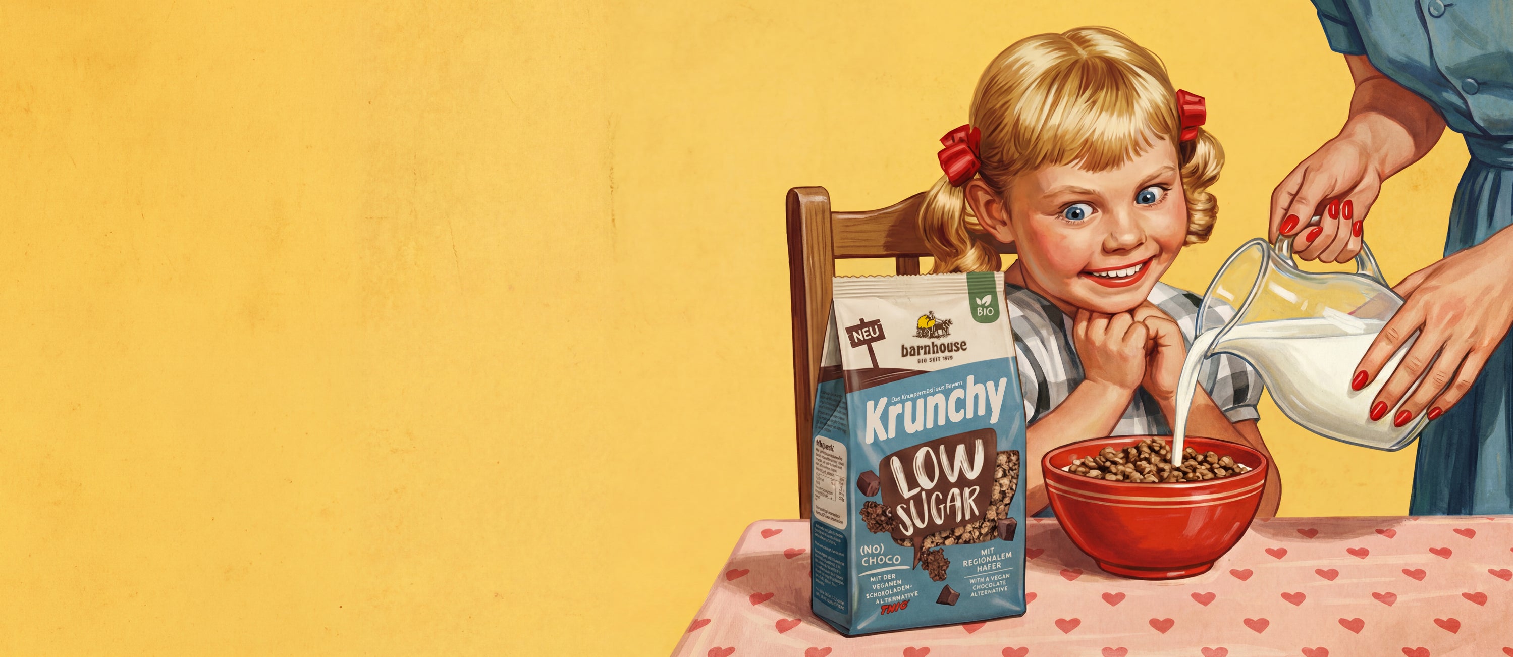 Bild in Comic-Optik: kleines, blondes Mädchen mit Zöpfen und roten Schleifen, das auf einem Holzstuhl sitzt. Vor ihr steht ein Tisch mit rosa Tischdecke, auf der rote Herzen sind. Das Mädchen blickt voller Freude auf einen blau-braunen Beutel Krunchy Low Sugar (No) Choco. Vor ihr steht eine rote Müslischüssel mit diesem Bio-Knuspermüsli. Vom rechten Bildrand schenkt eine Frau mit roten Fingernägeln im blauen Kleid Milch aus einer Karaffe in die Schüssel.