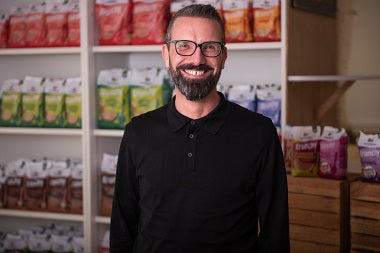 Andreas - Leitung Marketing & Produktmanagement - vor einem Regal mit Krunchy von Bio-Knuspermüsli-Hersteller Barnhouse.