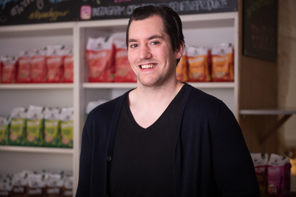 Produktentwickler Fabi vor einem Regal mit Krunchy von Bio-Knuspermüsli-Hersteller Barnhouse.