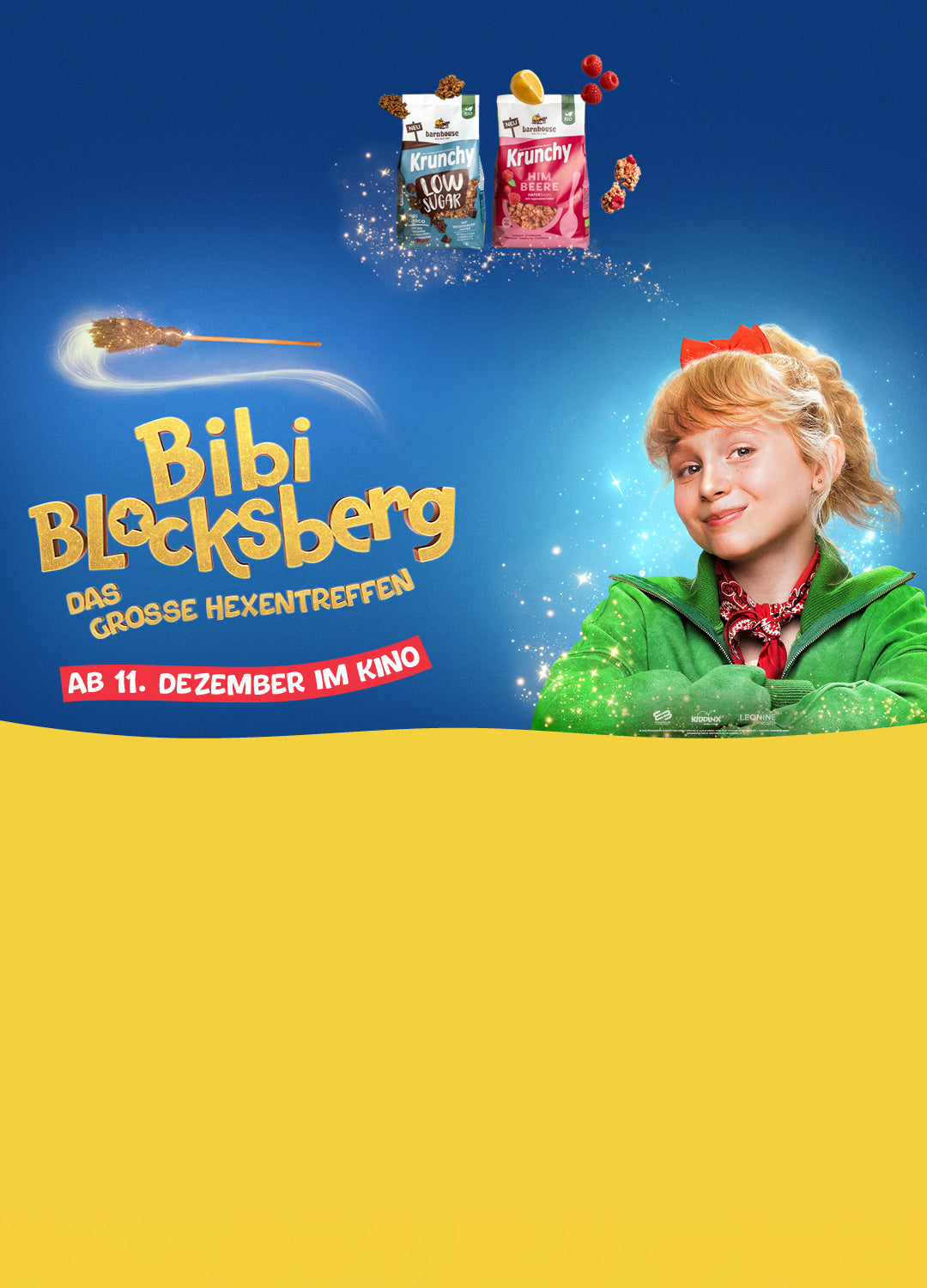Blondes, junges Mädchen mit grüner Jacke und roter Schleife. Außenrum Glitzer. Darüber 2 Krunchy-Beutel, Cluster, Himbeeren & 1 Zitrone. Links steht "Bibi Blocksberg - DAS GROSSE HEXENTREFFEN ab 11. Dezember im Kino", darüber schwebt ein Hexenbesen.