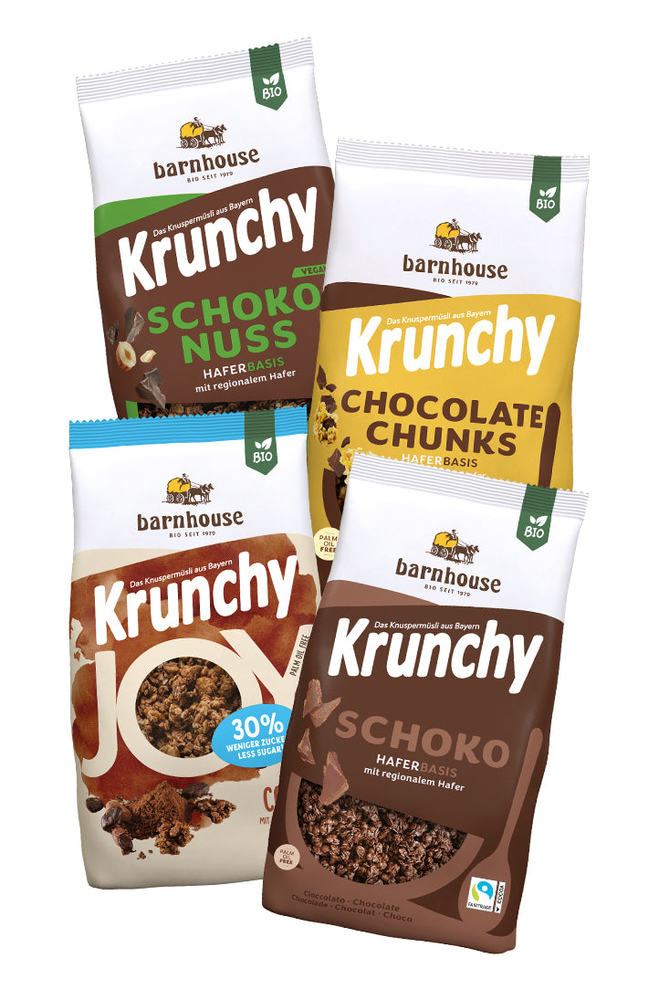 Blick von vorne auf die schräg in 2er Reihe angeordneten Packshots der vier Schoko-Krunchys Schoko-Nuss, Chocolate Chunks, Joy Cocoa und Schoko von Bio-Knuspermüsli-Hersteller Barnhouse.
