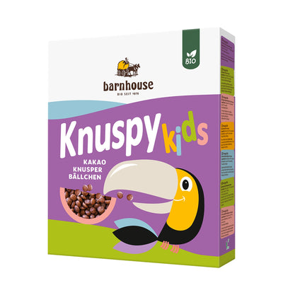 Violetter Karton Knuspy Kids des Bio-Knuspermüsli-Herstellers Barnhouse mit einem farbigen Tukan auf der Packung, der Knusopy Kids isst,