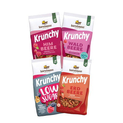 Blick von vorne auf die schräg in 2er Reihe angeordneten Packshots der vier Frucht-Krunchys Erdbeere, Waldbeere weniger Zucker, Low Sugar Very Berry sowie Himbeere von Bio-Knuspermüsli-Hersteller Barnhouse.